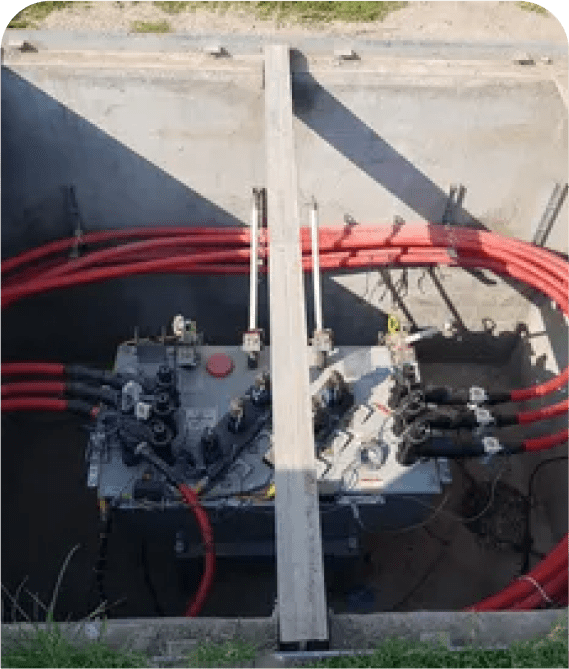 Electrical transformer with red cables underground.
