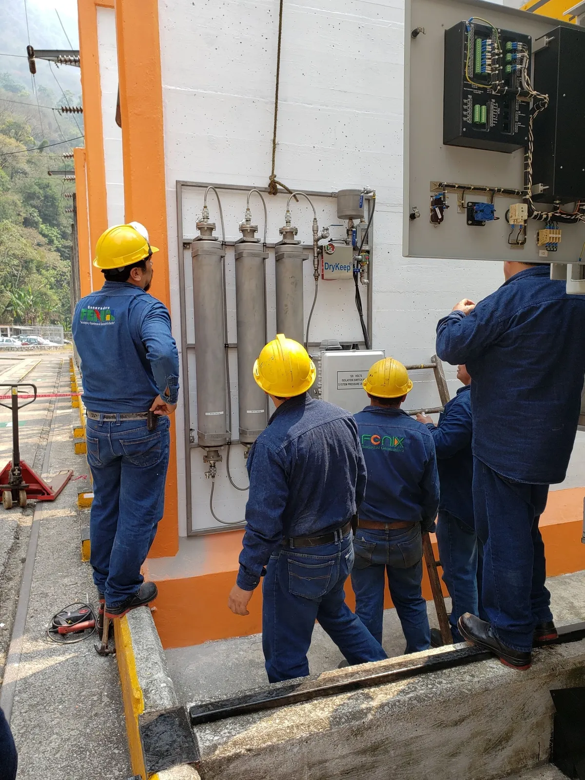 Workers inspecting industrial equipment outdoors.